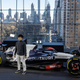 A photo of Yuki Tsunoda standing next to his 2023 AlphaTauri F1 car.